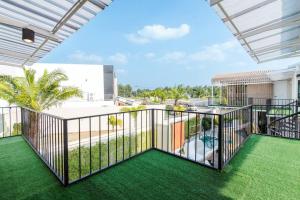- un balcon avec de l'herbe verte et un bâtiment dans l'établissement Poollay StayX4 Poolvilla@Pattaya พัทยา, à Ban Huai Yai