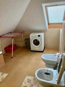 ein Badezimmer mit einer Waschmaschine und einem WC in der Unterkunft Sebastian Apartments in Třeboň