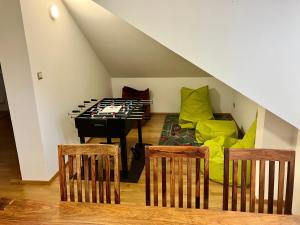 ein Wohnzimmer mit einer Tischtennisplatte und Stühlen in der Unterkunft Sebastian Apartments in Třeboň