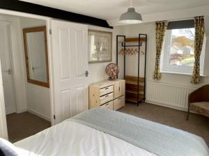 a bedroom with a bed and a dresser and a window at Taylor Way in Aberystwyth