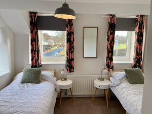 a bedroom with two beds and a window at Taylor Way in Aberystwyth