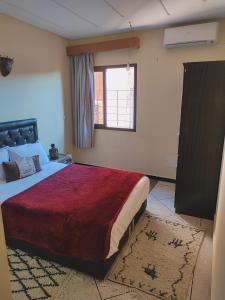 Un dormitorio con una cama grande y una ventana en Hostel Afgo Rooftop en Ouarzazate
