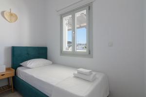 a white bedroom with a bed and a window at Nice And Spacious Apartment In Paros in Naousa