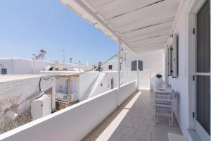 a balcony with a table and chair on a building at Nice And Spacious Apartment In Paros in Naousa
