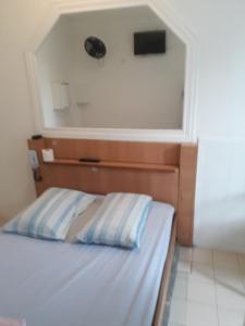 1 dormitorio con 1 cama con cabecero y ventana en Hotel Prince, en São Paulo