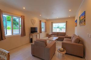 a living room with two couches and a tv at Lovely Caribbean family villa with private pool in Willemstad