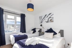 two beds in a room with a window at 19A Apartment- Stylish & Cozy 1BR in The Heart of Crawley in Crawley
