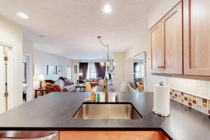 a kitchen with a sink and a living room at Winterplace Condos K in Ludlow