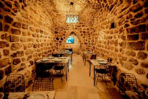 a dining room with tables and chairs in a stone wall at CARRA KONAĞI in Mardin