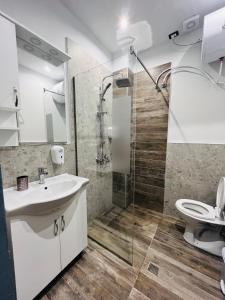a bathroom with a toilet and a sink and a shower at Colombia Apartments&Rooms in Durrës