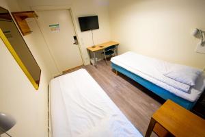 Cette petite chambre comprend un lit et un bureau. dans l'établissement Vandrarhem Kvarntorget, à Uppsala