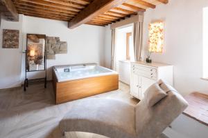 巴贝里诺·迪·穆杰罗Il Castelluccio Country Resort Restaurant & SPA的带沙发的房间内配有浴缸的客厅