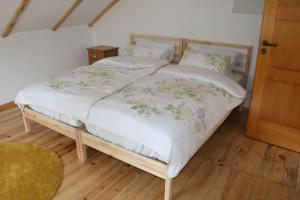 Cette chambre comprend un lit avec un cadre en bois. dans l'établissement Klasztor 5 Borowy Mlyn, à Lipnica