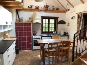 a kitchen with a wooden table and a stove at Klasztor 5 Borowy Mlyn in Lipnica