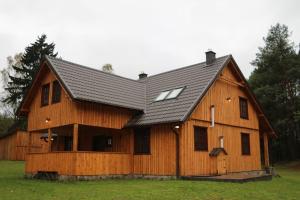 une grande grange en bois avec un toit en gambrel dans l'établissement Klasztor 5 Borowy Mlyn, à Lipnica