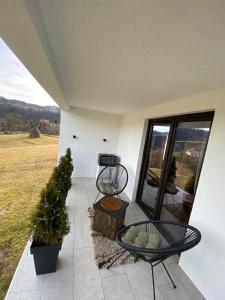 a patio with two chairs and a table and a window at Vila Luka i Ana - Apartman Luka in Zaovine