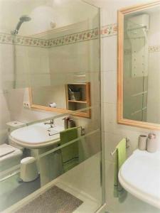 Baño blanco con lavabo y espejo en Apartamento Ayla Camino de Santiago, en Pamplona