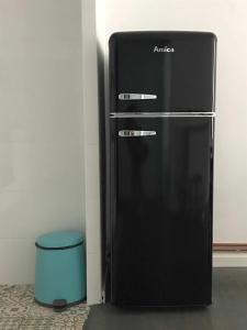 a black refrigerator in a room with a blue stool at Apartamento Ayla Camino de Santiago in Pamplona