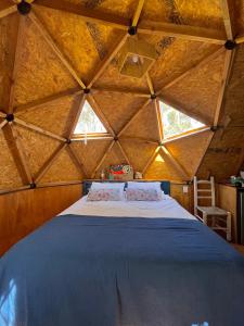 1 dormitorio con cama grande en el techo de madera en DomosdeMar en Ocean Park