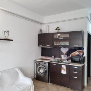een keuken met een fornuis en een wasmachine bij Sky Studio in Constanţa