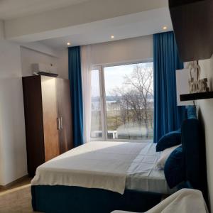 een slaapkamer met een groot bed en een groot raam bij Sky Studio in Constanţa