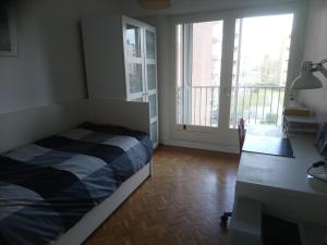 Schlafzimmer mit einem Bett, einem Schreibtisch und Fenstern in der Unterkunft OPALINE T3 lumineux avec patio et parking privé in Dunkerque