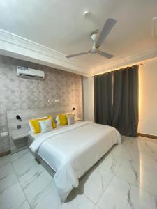 a bedroom with a large white bed with yellow pillows at MILTON AVENUE SUITES in Accra