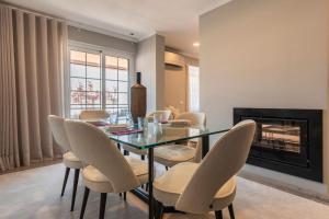 een eetkamer met een glazen tafel en stoelen bij Seaview Luxury Apartment in Cascais