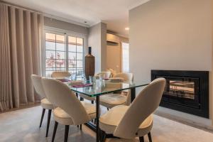 Un comedor con una mesa de cristal y sillas. en Seaview Luxury Apartment, en Cascais