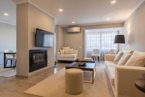 a living room with a couch and a fireplace at Seaview Luxury Apartment in Cascais
