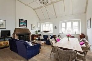 a living room with a table and a fireplace at The Old School - Beautiful Country House, Period Features with Modern Decor, Great Entertaining Space in Icklesham