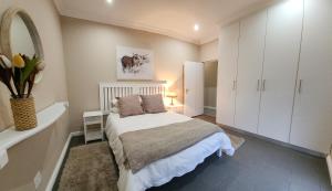 a white bedroom with a bed and a mirror at Bon Game Private Reserve in Blandʼs Drift