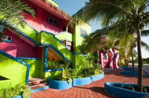 un edificio colorido con palmeras delante en Del Sol Beachfront, en Akumal