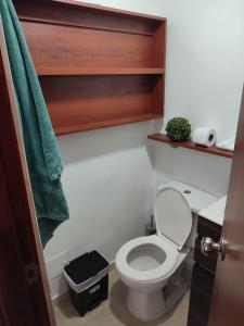 a bathroom with a toilet and a green towel at Habitación privada con vista a la ciudad in Pereira