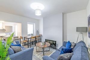 un soggiorno con divano blu e tavolo di 3 Bedroom Holiday Home within Kensington a Liverpool