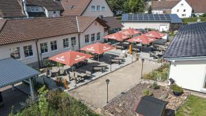 einen Blick über ein Restaurant mit Tischen und Sonnenschirmen in der Unterkunft Gasthaus Johanning eK in Uslar