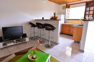 a living room with two stools and a flat screen tv at Appartement d'une chambre avec jardin clos et wifi a La Trinite a 6 km de la plage in La Trinité