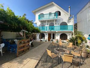 ein weißes Haus mit Stühlen und einem Tisch davor in der Unterkunft Hostal Dolegant Pichilemu 2 in Pichilemu