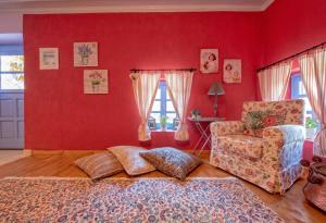 a living room with red walls and a chair at Minodora's Guesthouse in Dikorfo