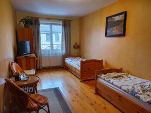 a small room with two beds and a television at Penzión U Jakuba in Kežmarok