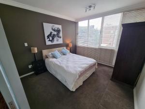 a bedroom with a bed and a large window at Walk frm Mandela Square, Sandton City and Gautrain in Johannesburg