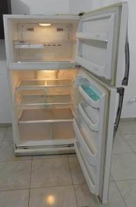 an empty refrigerator with its door open in a kitchen at Stop and Chill in Playas