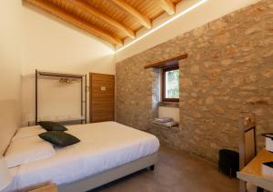 una camera con letto e parete in pietra di Tenuta San Martino a Nusco