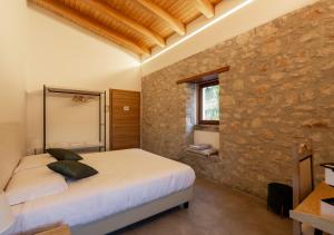 a bedroom with a bed and a stone wall at Tenuta San Martino in Nusco