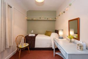1 dormitorio con cama, escritorio y espejo en Courtyard Flat - Kendal, en Kendal