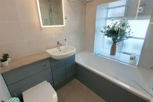 a bathroom with a sink and a tub and a toilet at Courtyard Flat - Kendal in Kendal
