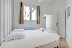 Un dormitorio blanco con una gran cama blanca y una ventana en Magnificent renovated apartment - Paris Expo Porte de Versailles en París