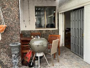 un patio con parrilla, mesa y sillas en Casa Momo, en Porís de Abona
