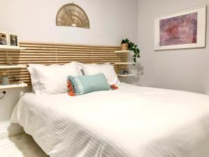 Una cama blanca con una almohada azul encima. en Your cozy downtown home - Apartment, en Larisa