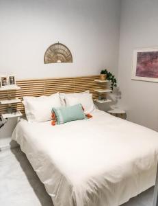 1 cama blanca grande con almohadas blancas en Your cozy downtown home - Apartment, en Larisa